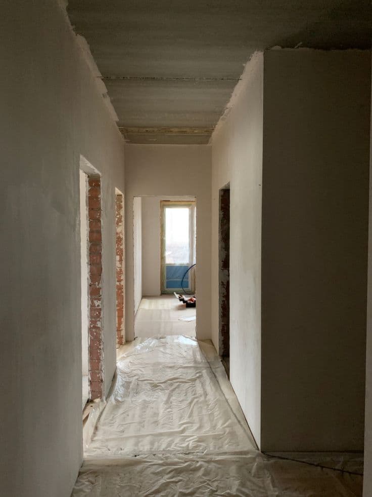 Pasillo interior con muros y acabados en proceso de construcción